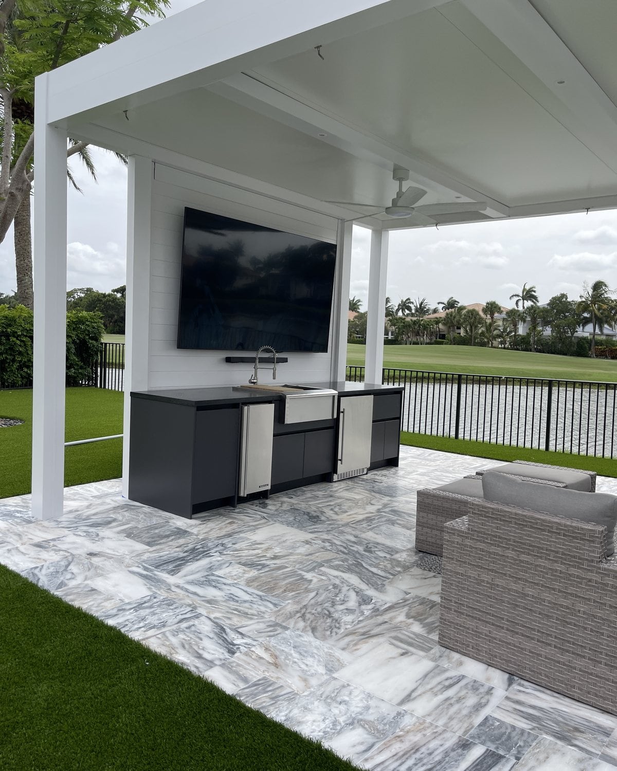 LANDIIN design study: charcoal outdoor kitchen run with sink and refrigeration under a white pergola